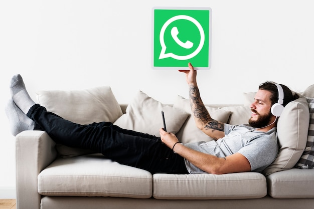 Free photo man showing a whatsapp messenger icon