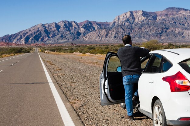 Man on the side of the road enjoying landscape