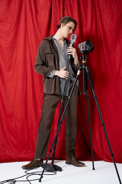 Free photo man singing with microphone full shot