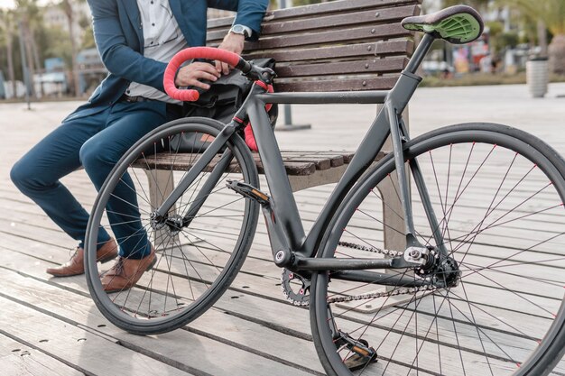 Man sitting on a bench next to his bike outdoors