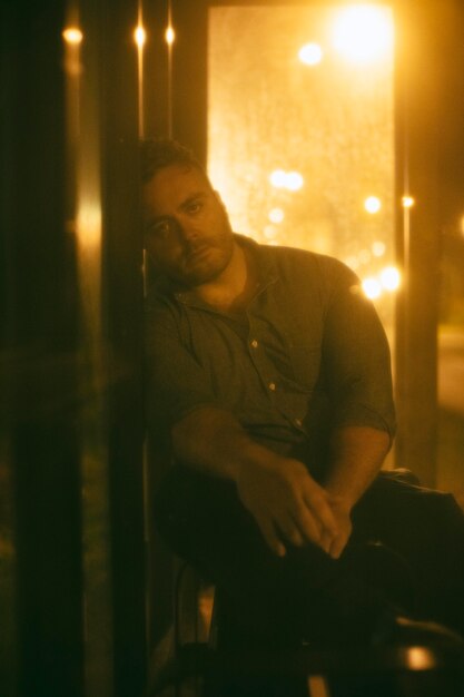 Man sitting at the bus station at night in the city