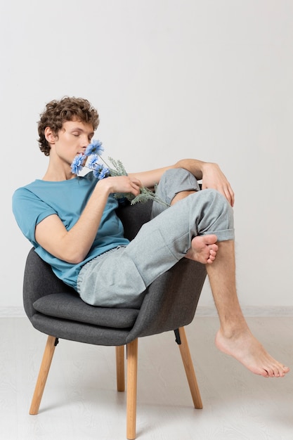 Man sitting in chair and holding flowers