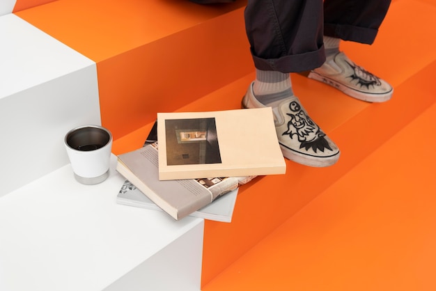 Free Photo man sitting at the coffeehouse next to books and coffee cup