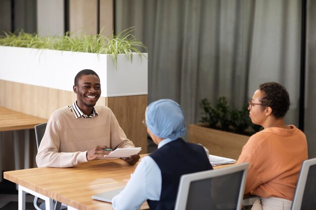 Man sitting down for an office job interview at desk with his employers