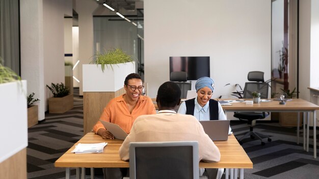 Man sitting down for an office job interview at desk with his employers