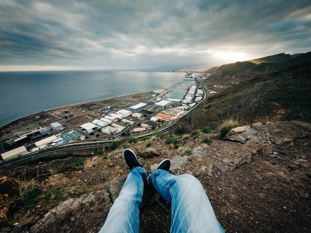 Free photo man sitting on a hill and enjoying the view