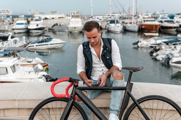 Free photo man sitting next to his bike