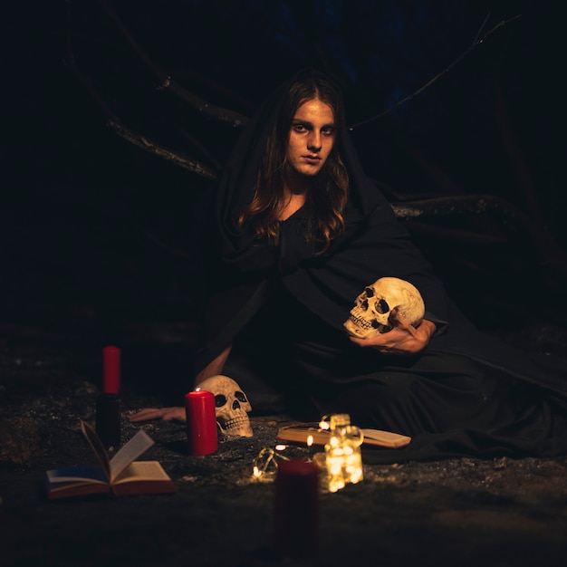 Man sitting and holding a white skull