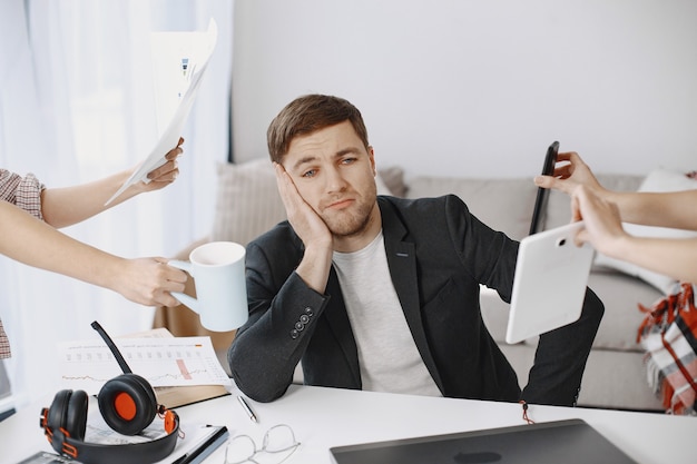 Free photo man sitting in living room at home. sad man tired from work.