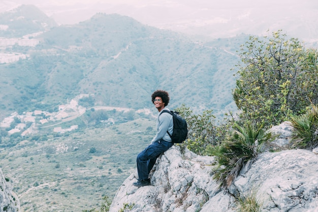 Free Photo man sitting on rock in nature