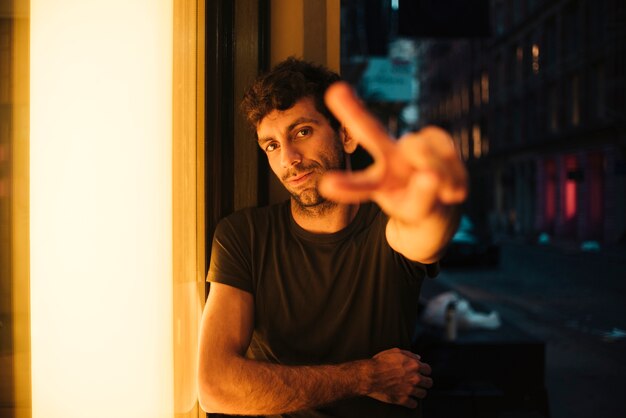 Man sitting and showing peace sign