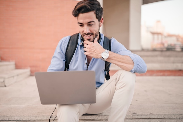 Man sitting on staircase using laptop