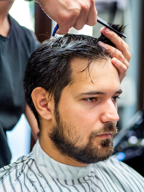 Man sitting still and getting a haircut