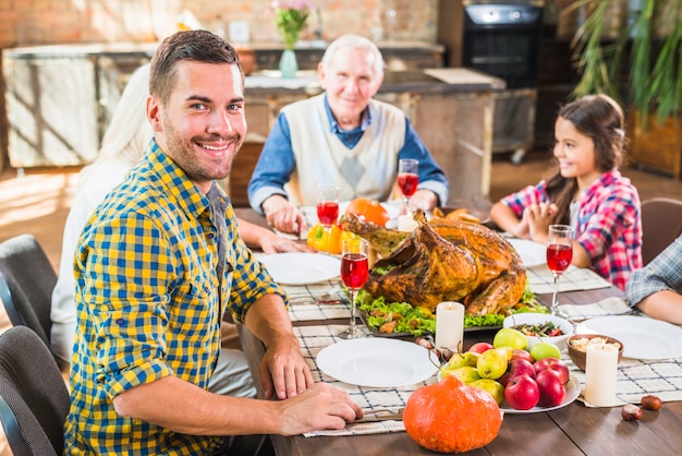 Free Photo man sitting at table near family 