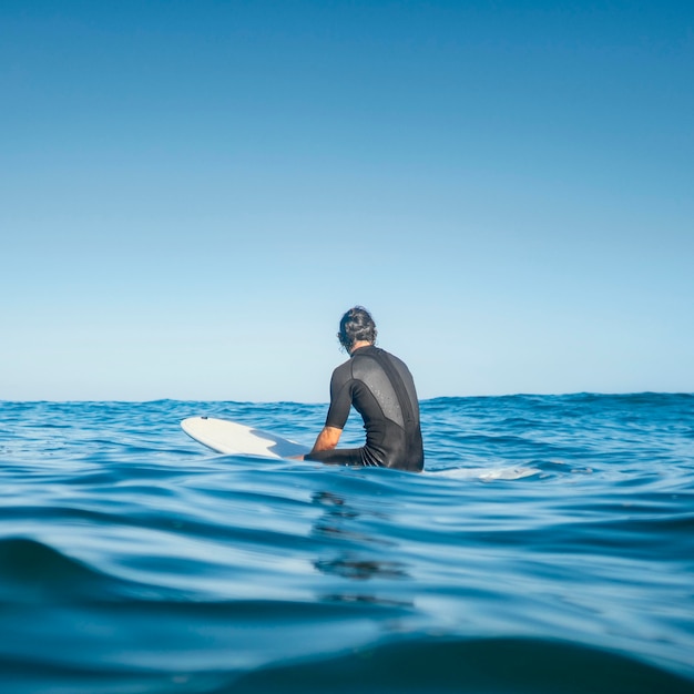 Man sitting in the water from behind