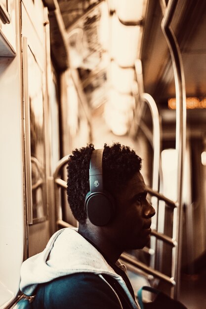 Man sitting and wearing headphones inside train