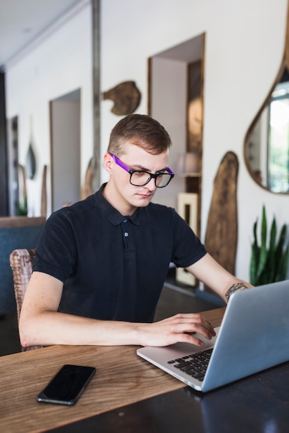 Man sitting with laptop in cafe 