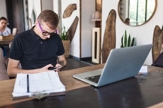 Man sitting with smartphone in cafe 