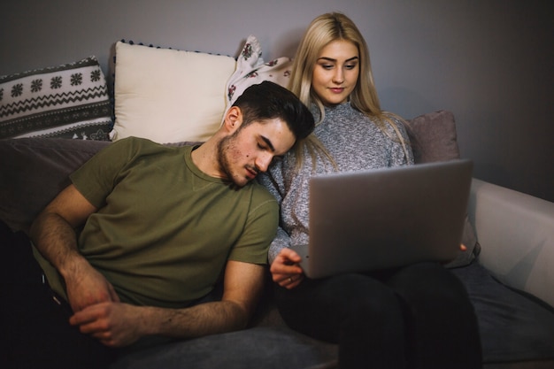 Man sleeping near woman watching film