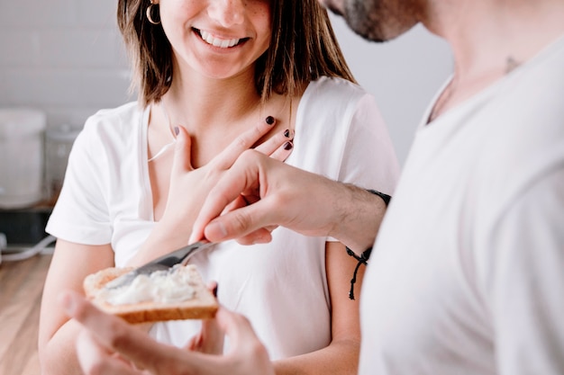 Man smearing butter on toast for woman