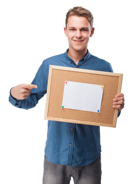 Man smiling with a blank paper on a board