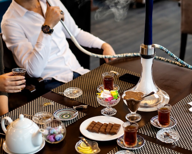 Free photo man smokes hookah and woman drinks tea