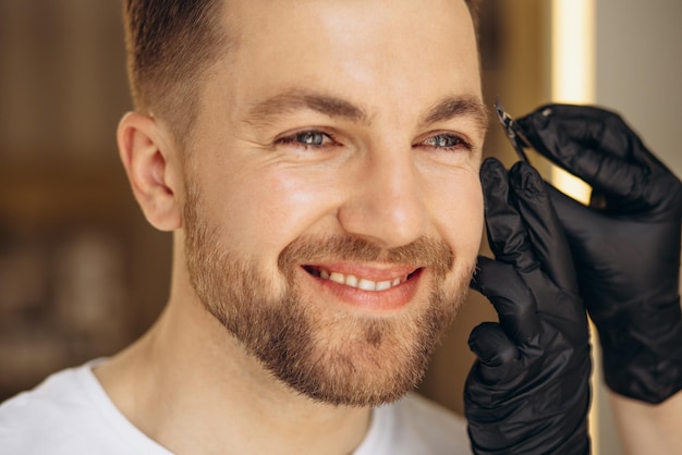 Man at spa making treatment for his eyebrows