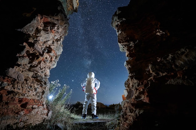 Free photo man in spacesuit is looking in starry sky