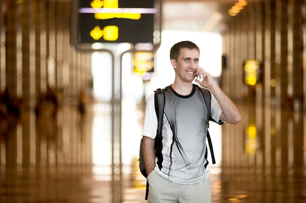 Free photo man speaking on smartphone in airport