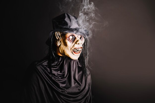 Man in spooky mask on black