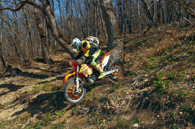 Man in sport equipment riding a motorcross bike in mountains