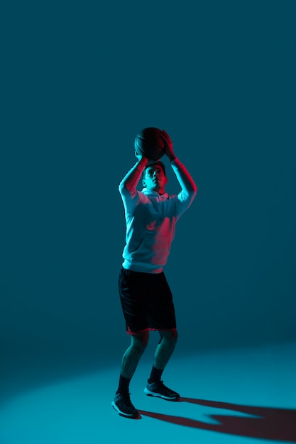 Man in sportswear playing basketball with cool lights