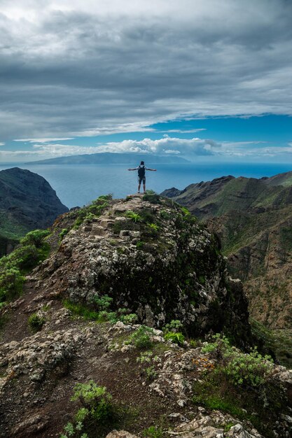 Man standing on the hill against background of the beautiful mountain landscape