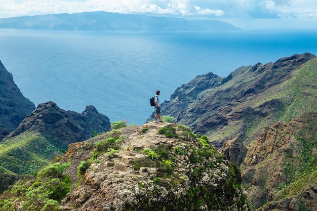 Man standing on the hill against background of the beautiful mountain landscape