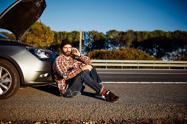 Man standing next to his broken car