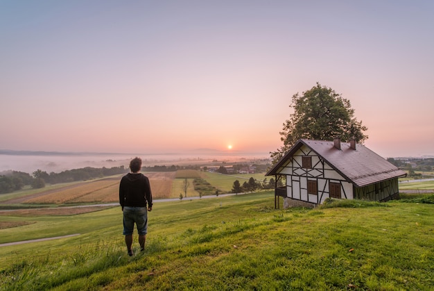 Free Photo man standing near house and tree at daytime