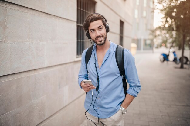 Man standing on pavement listening to music