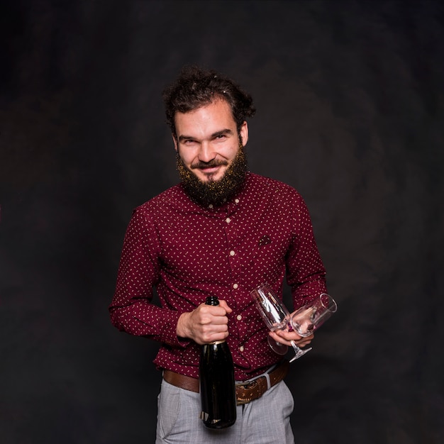 Man standing with champagne bottle and glasses 