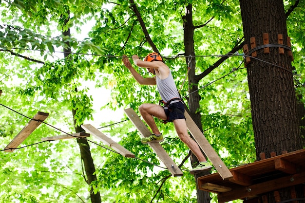 Free photo man steps on the wooden blocks hanging in the air