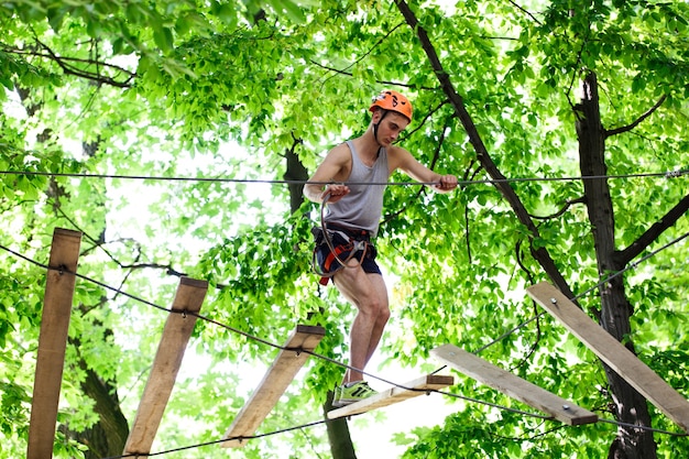 Man steps on the wooden boards hanging in the air