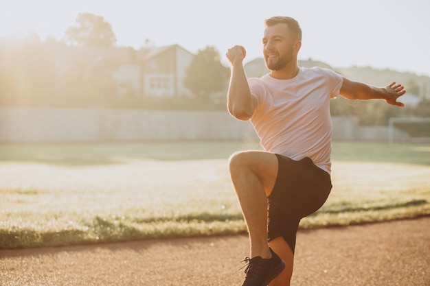 Man stretching before workout at the stadium