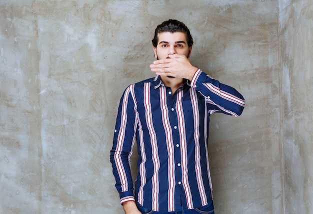 Man in striped shirt looks scared and thrilled.