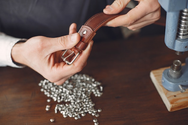 Man in a studio creates leather ware