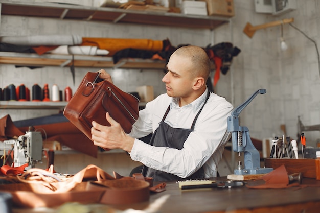 Free Photo man in a studio creates leather ware