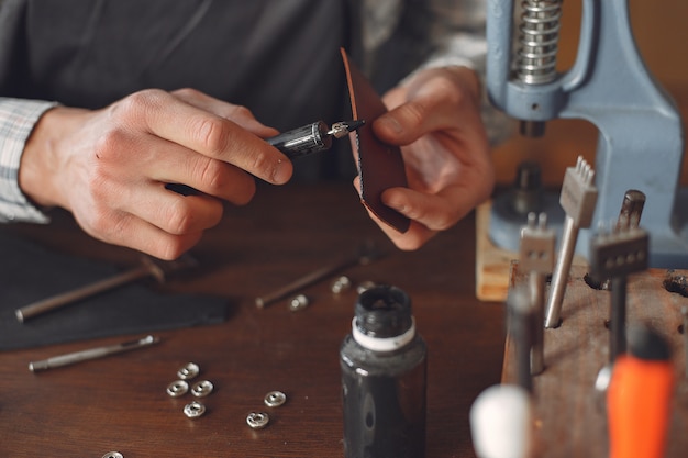 Man in a studio creates leather ware