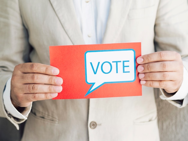 Free photo man in suit holding a voting message