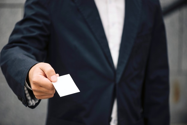 Free Photo man in suit offering visiting card