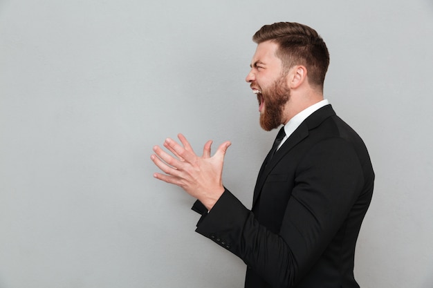 Free photo man in suit shouting and gesturing with hands