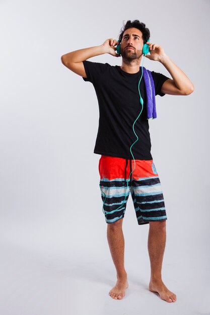 Man in summer wear trying out headphones