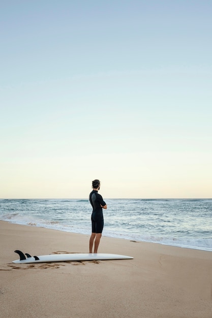 Man and surfing board at the ocean long shot